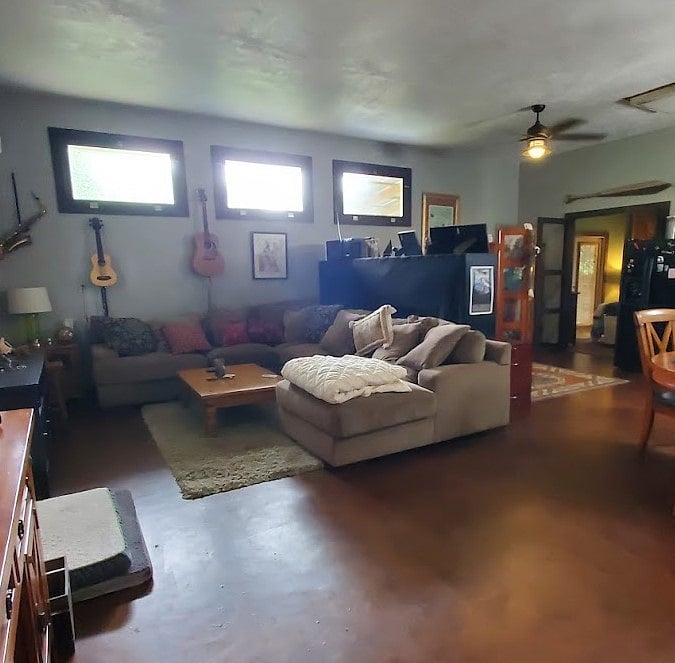 Living room with large wrap-around sofa with large screen TV and apple TV on opposite wall.