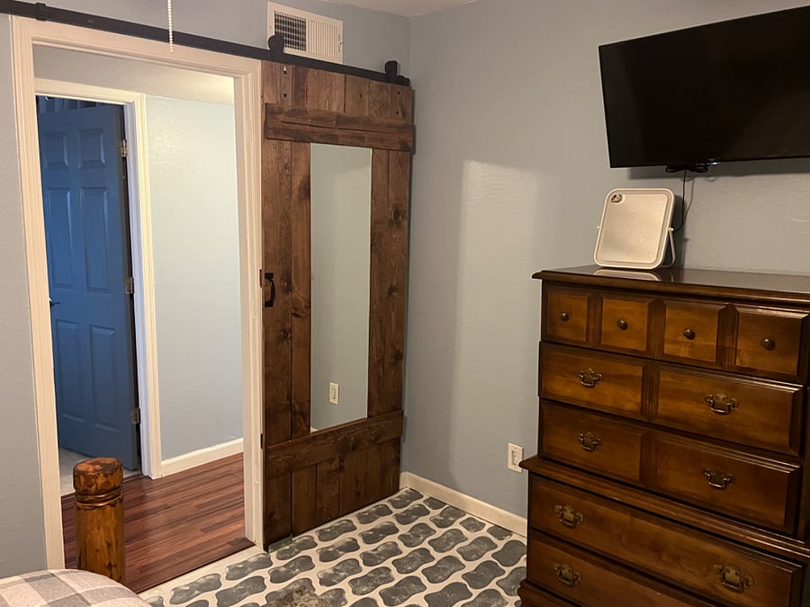 Main Bedroom, 32 inch smart tv, barn door with full mirror, and dresser