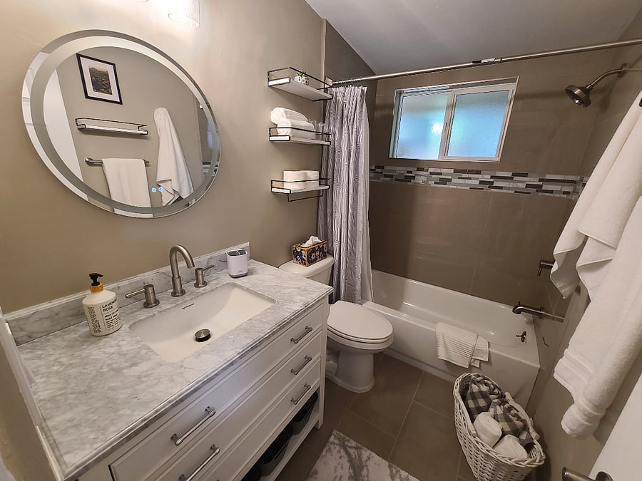 The roomy bathroom has a shower/tub combination plus and LED vanity light.