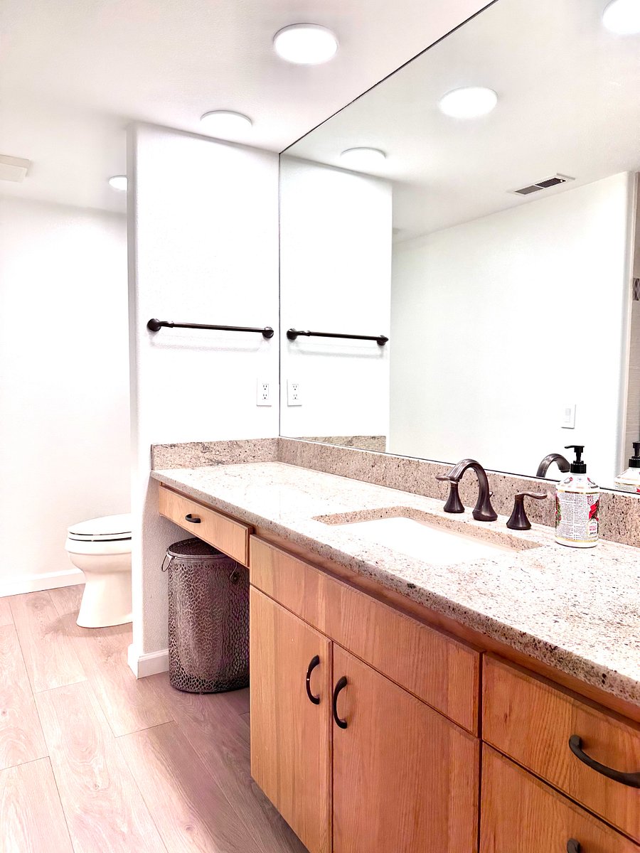 Modern bathroom with large mirror and ample light and space.