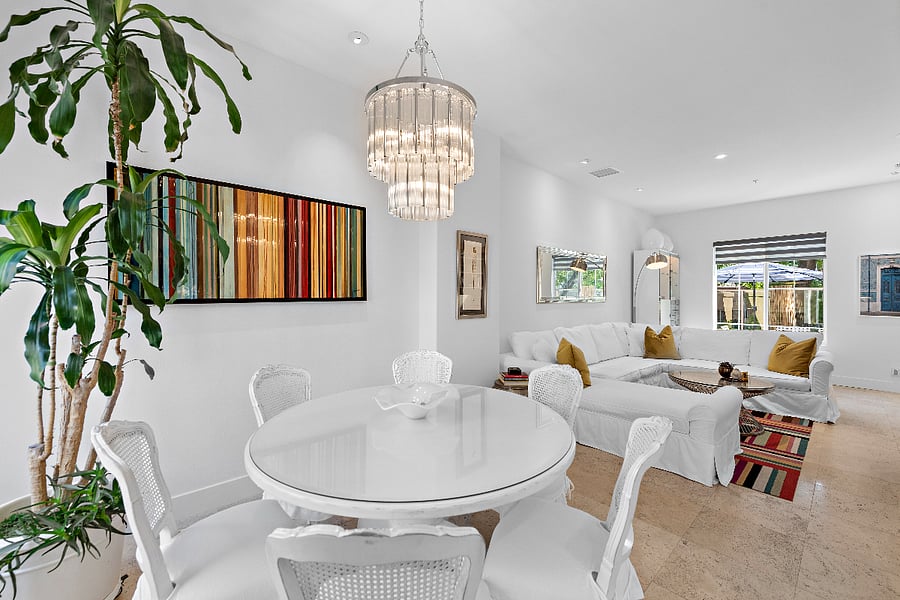 Second level kitchen, dining and living room with direct access to patio with view of high rise building.
