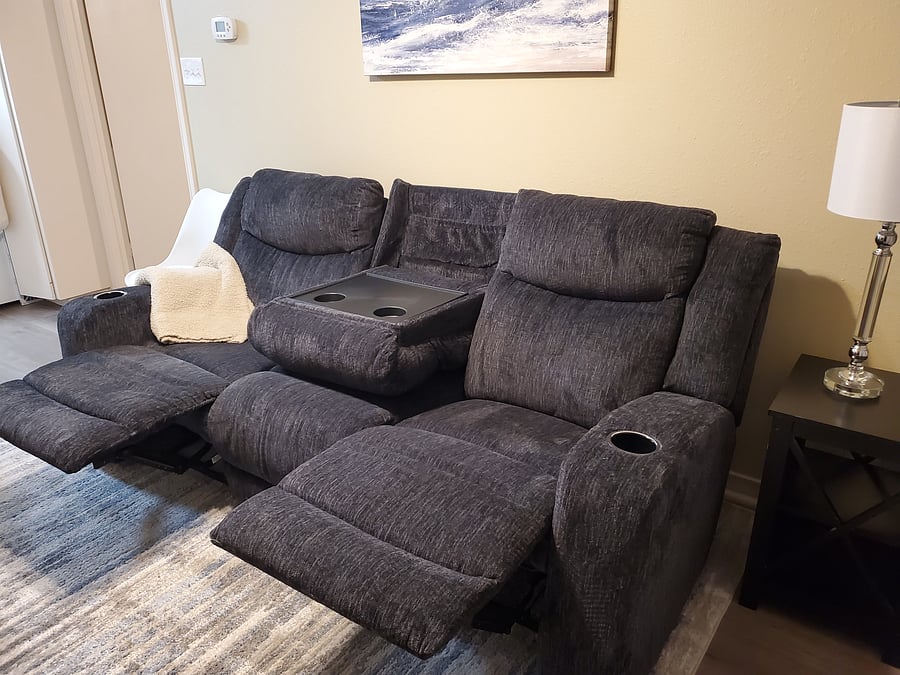 The couch has cupholders and reclines.