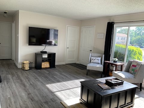 Living room showing front room windows, front entrance, hallway to bedrooms, and location of TV
