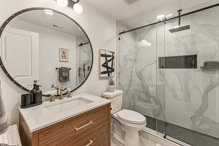 Beautiful modern bathroom with quartz countertop vanity and oversized mirror. 