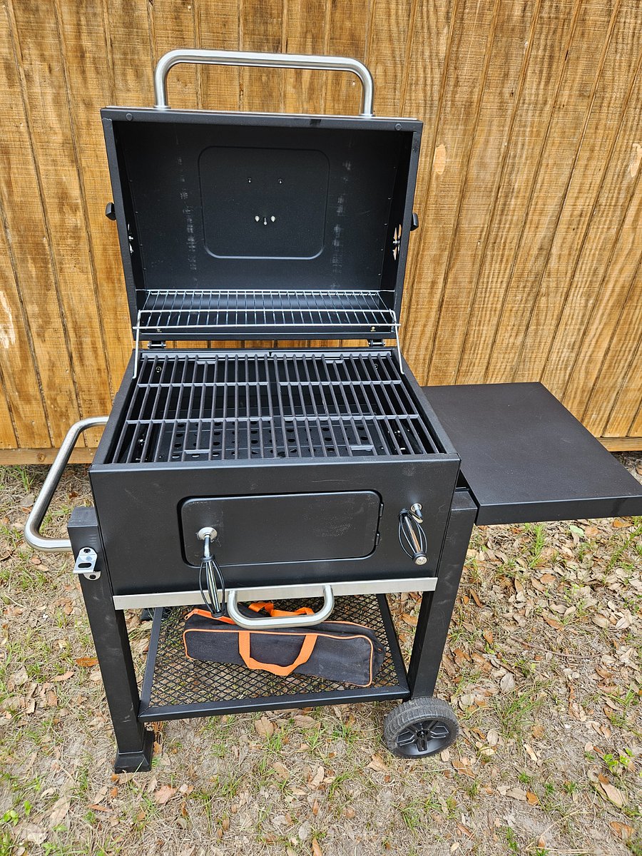 Community charcoal grill with utensils.