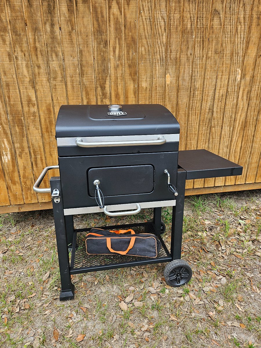 Community charcoal grill with utensils.