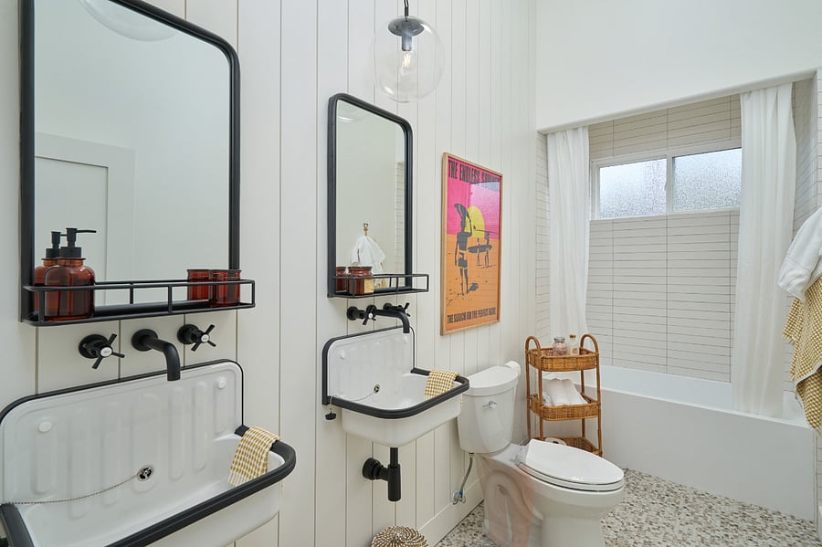 Guest bathroom with dual vanity sinks and shower/tub combination.