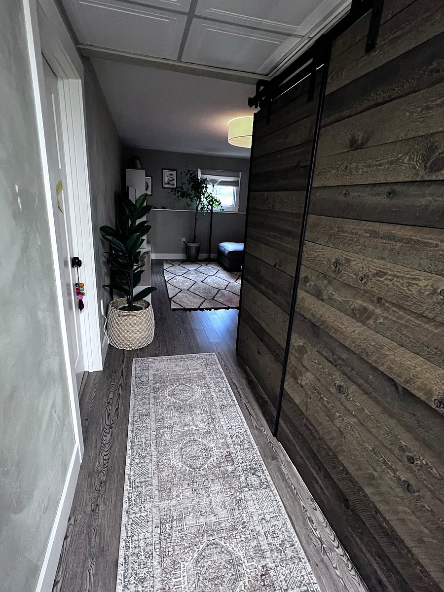 Washer/dryer and utility sink behind custom sliding barn doors