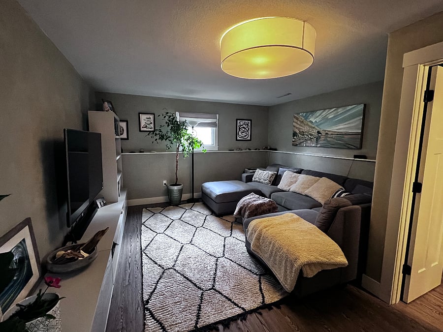 Basement living room with large sectional, and book shelves