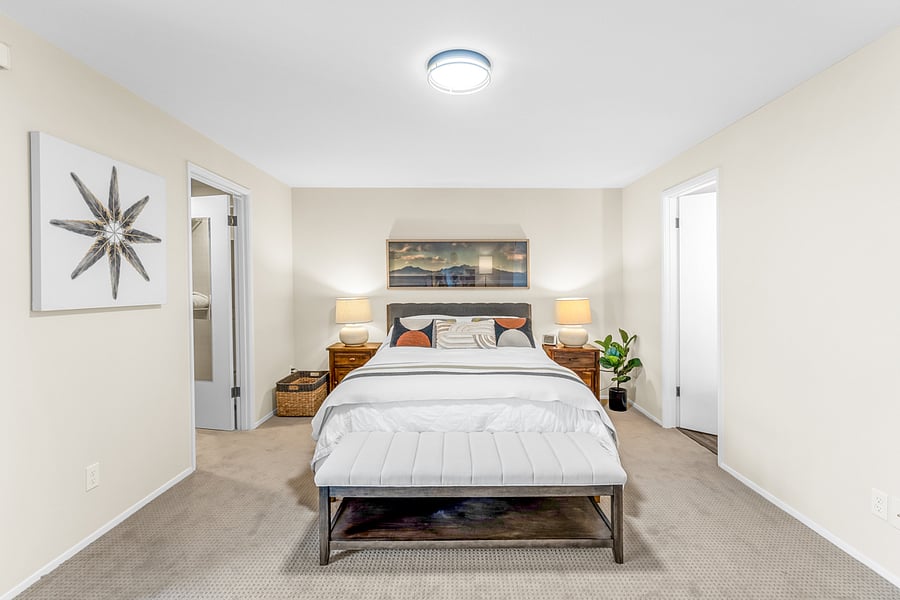 Large primary bedroom with queen bed, walk-in closet, and attached bath