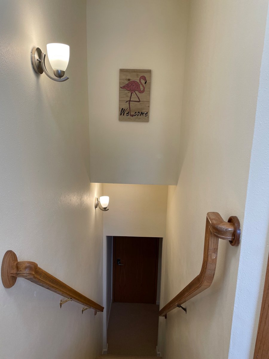 Stairs down to the apartment with handrails on either side