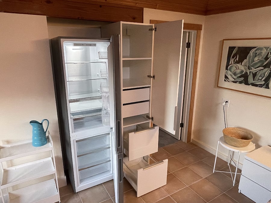 Fridge & pantry open to show space available for cold and dry food storage.