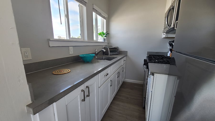 galley kitchen with stainless steel appliances (microwave, full size fridge, gas range)