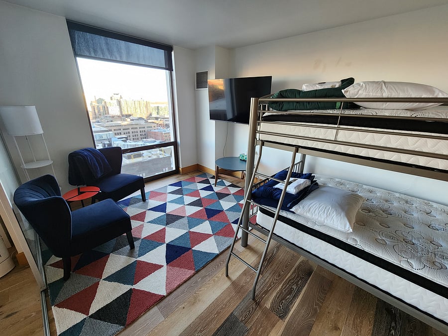 Second bathroom with Full Bunk Bed, two armchairs and tv. Sliding door opens to living room.