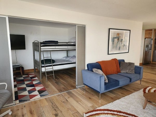 Living Room with sliding door to bunkroom with full size bunk beds.