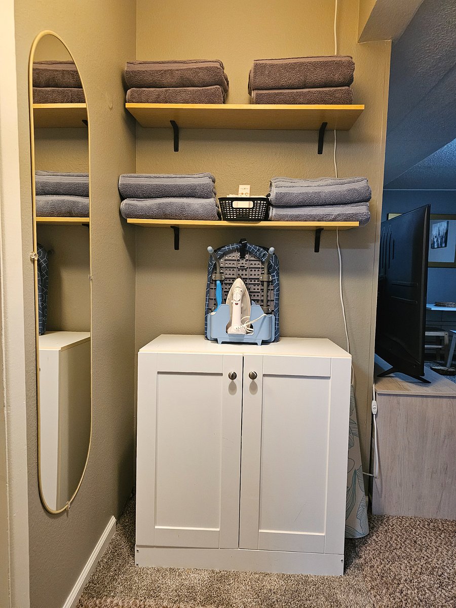 Fully stocked with wash cloths towels linen and a small ironing board and an iron 