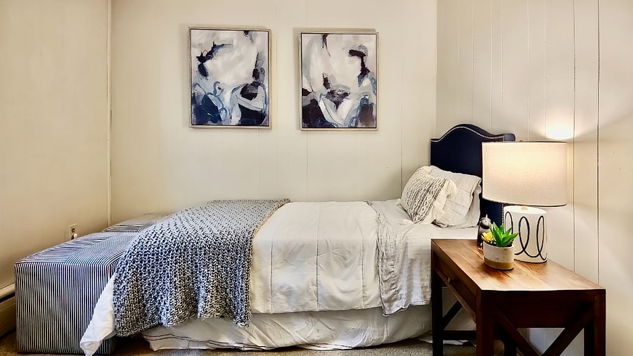 Twin bedroom with small dresser. Bed can be removed and replaced with desk to create private office.
