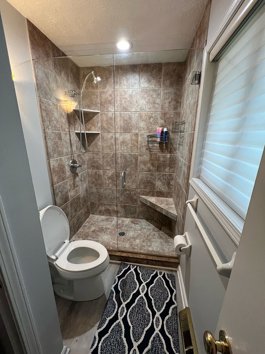 Master Bath: Handheld rainfall shower head. Multiple wall storage racks + shelves + shower bench.