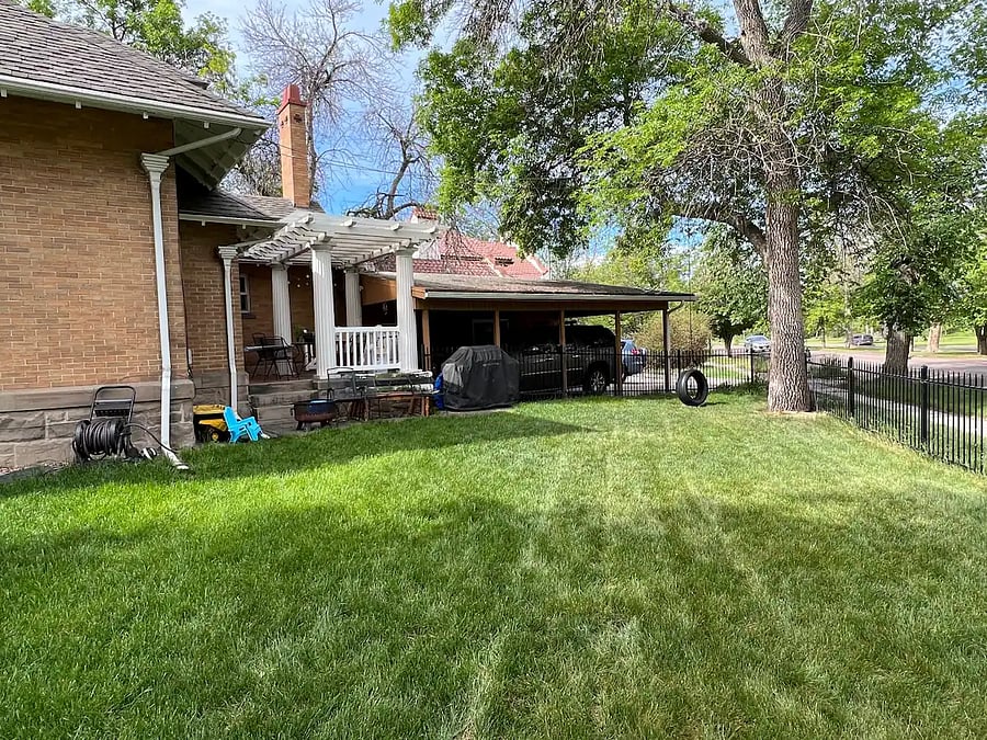 Side yard across from park, with grill and outdoor dining on patio. Parking available in garage, carport, and in front of garage. Street parking also available. 