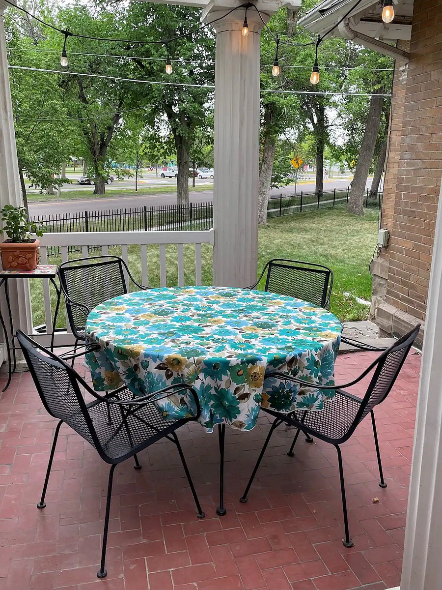 Back porch with outdoor dining, near grill and fenced yard area. 