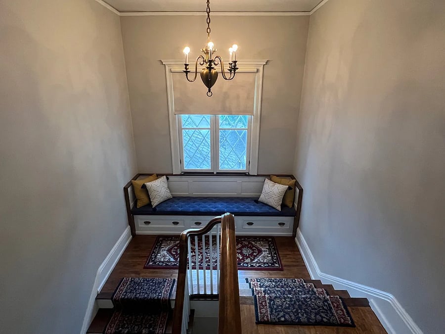 Cozy reading nook on stair landing.