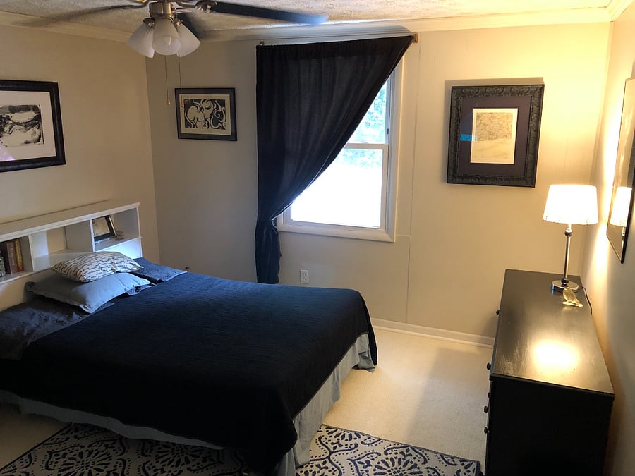 Bedroom with blackout curtains and original artwork