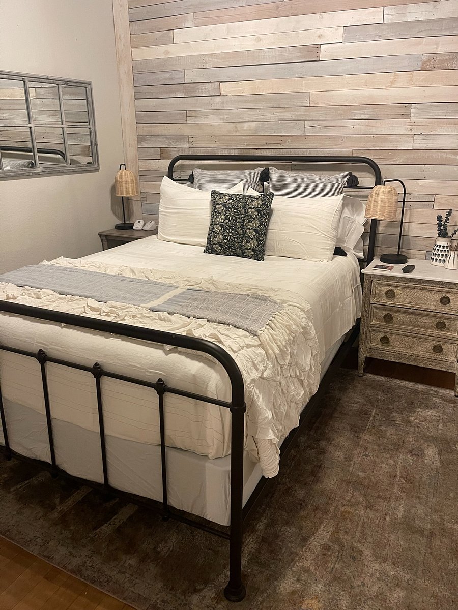 Main Bedroom: Tucked behind a beautiful rustic barn door, enjoy a cozy Queen sized bed, dresser, full length mirror, TV and closet space for hanging clothes.