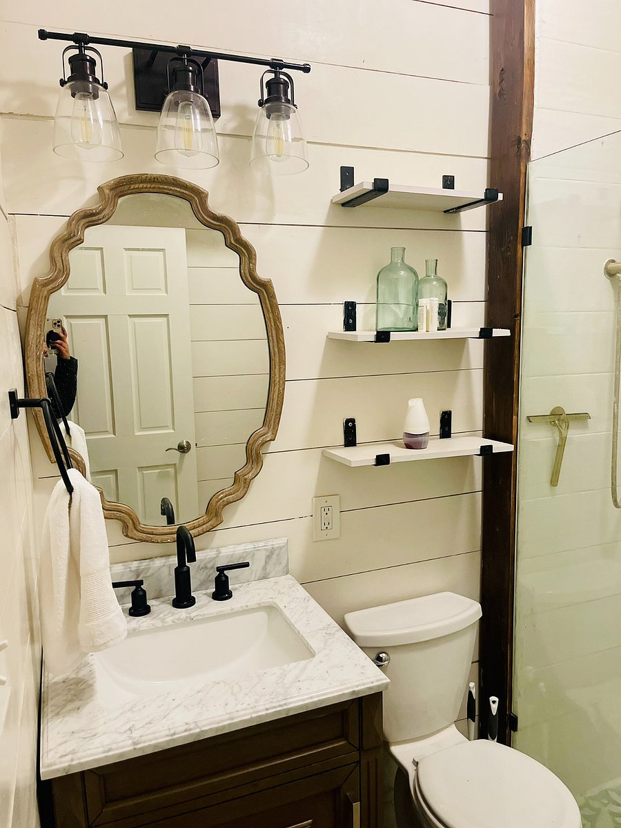 Bathroom: Take in the eclectic tilework, exposed brick and faux foliage dcor in the bathroom while you enjoy the rainfall shower. Find bath linens under the sink in the single bathroom vanity & all bathroom essentials on the shelves.