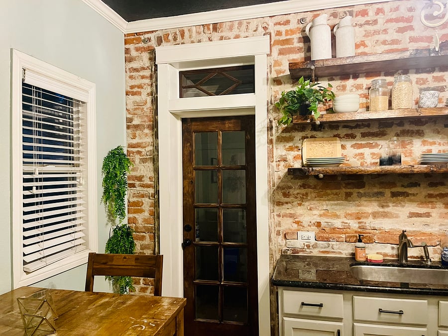 Kitchen: Beautiful exposed brick and live edge wood shelves. Have breakfast at the bar height kitchen table for 2. The kitchen comes equipped with all of the essential cookware, dinnerware, and common kitchen appliances.