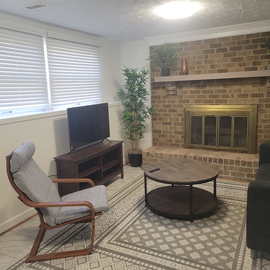 TV sitting area with fireplace in basement.