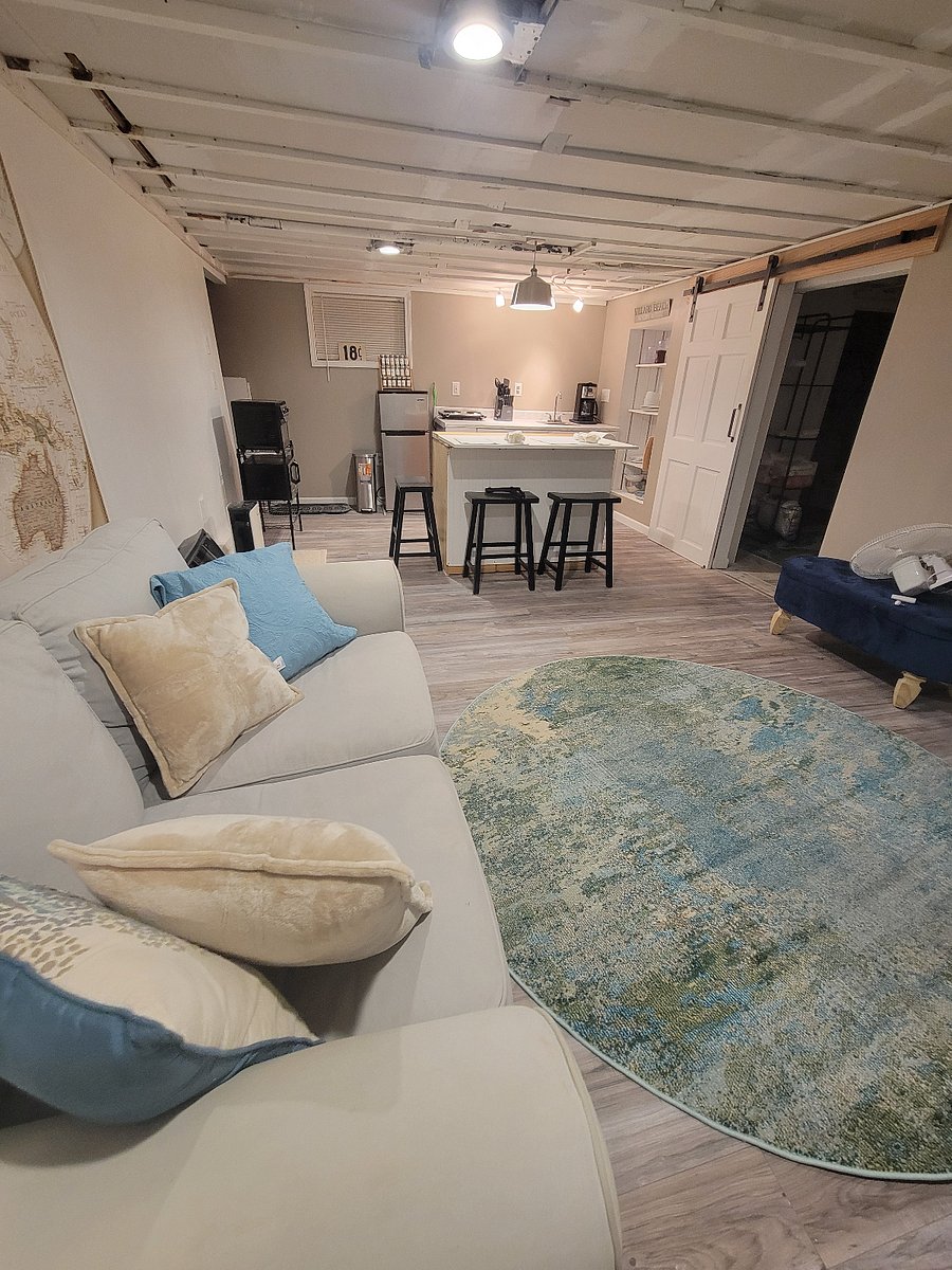 Comfortable open concept living room dining area with natural light from windows.  Sliding barn door separates bedroom/bathroom ensuite