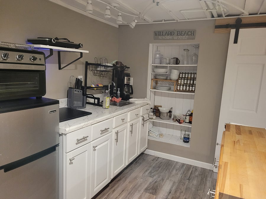 kitchenette with modern appliances, cooking utensils, spices and dishes