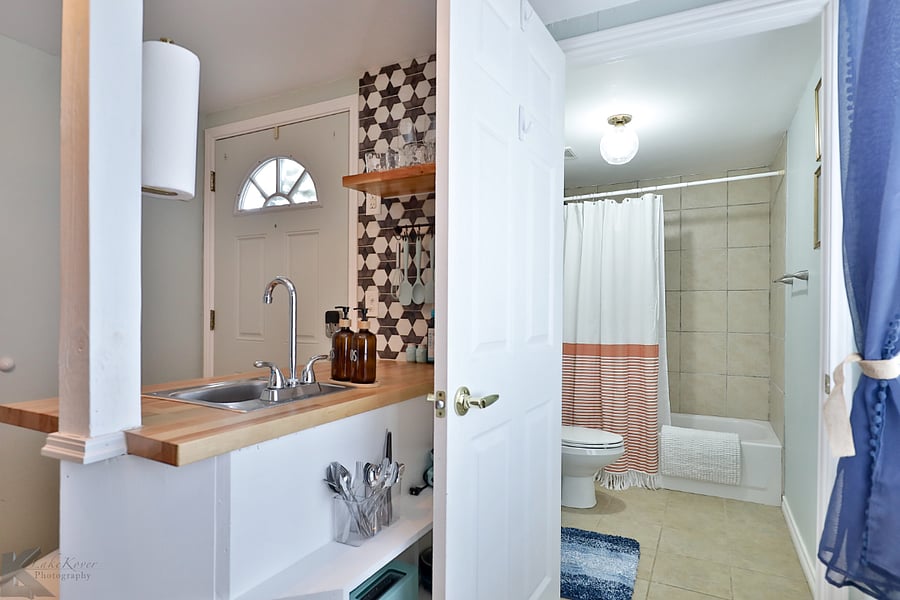 Hooks + hangers are located on the bathroom door for your hanging items.
