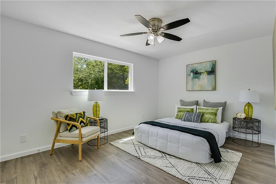 Large primary bedroom with king size bed, desk for dedicated workspace, dresser, large walk in closet, and in unit washer/dryer.
