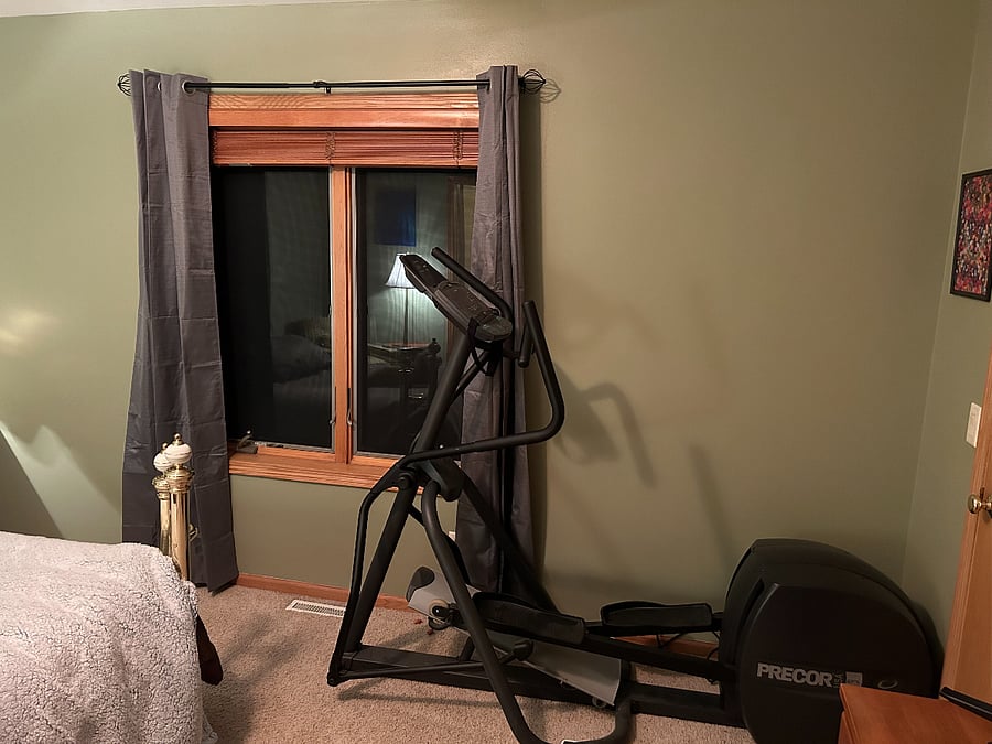 View of Master Bedroom side wall - window and elliptical machine for your work out needs.