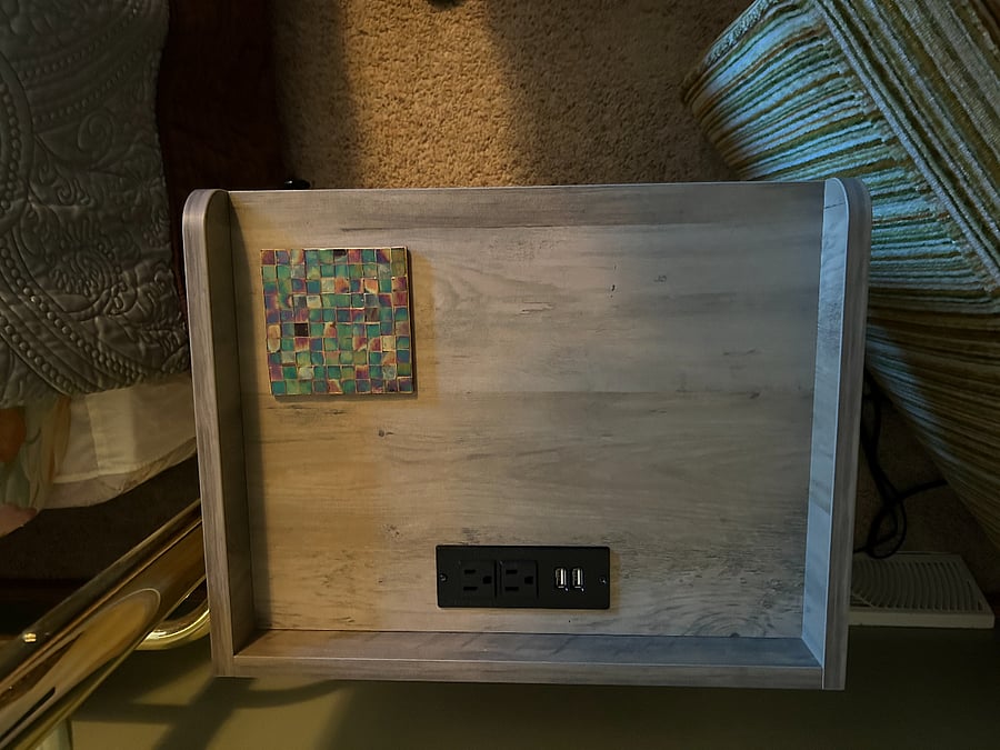 Top of nightstand showing the built in USB ports and electrical outlets to easily charge your phone / tablet / computer.