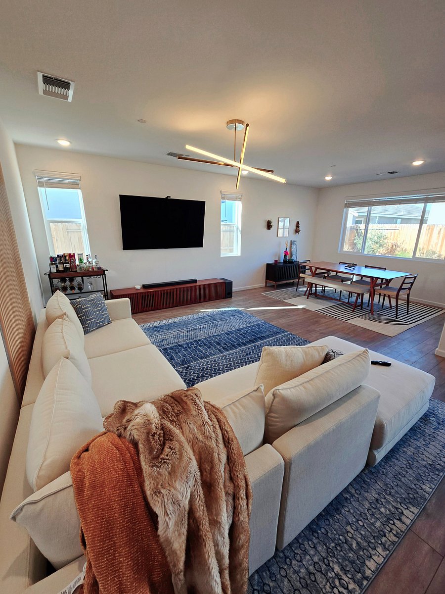 General living area with large dining table, open area, and 77" OLED with Dolby Atmos sound bar.