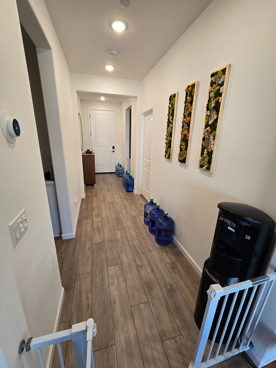 Displaying shared entrance and split wing hallway separating private room from the rest of the home for increased privacy. Shown is water dispenser for heated and cool water.