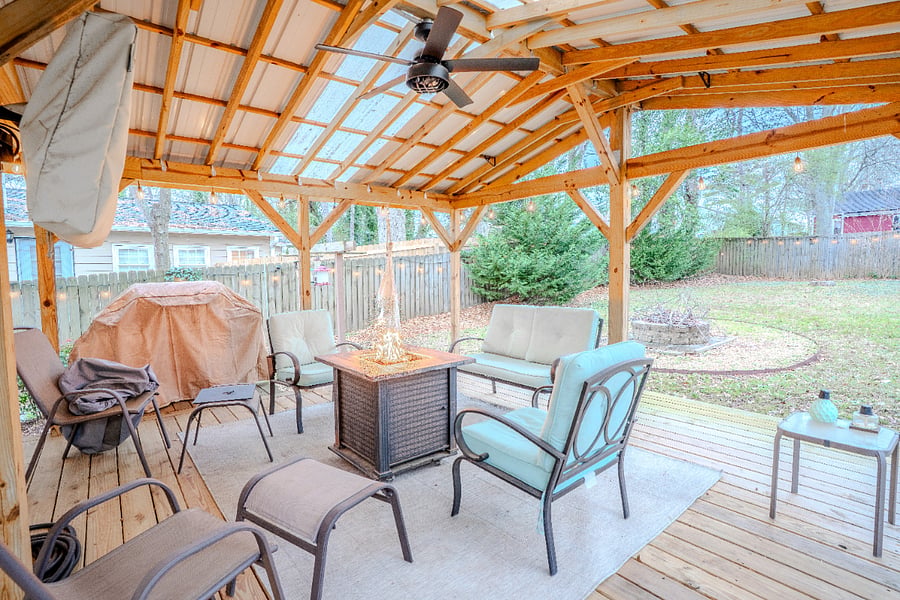 Back deck with TV, propane fire pit, and gas grill.