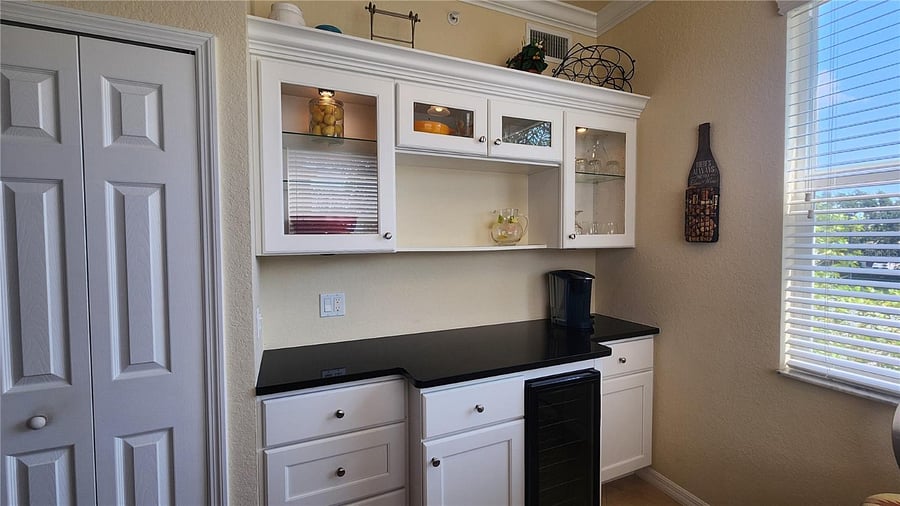 Breakfast nook include wine cooler, glasses and 2 coffee makers below.