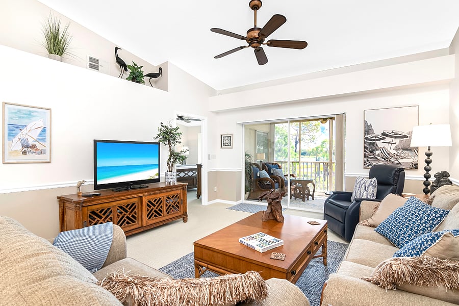 Living room with lanai access, smart 65-inch TV and beautiful furnishings.