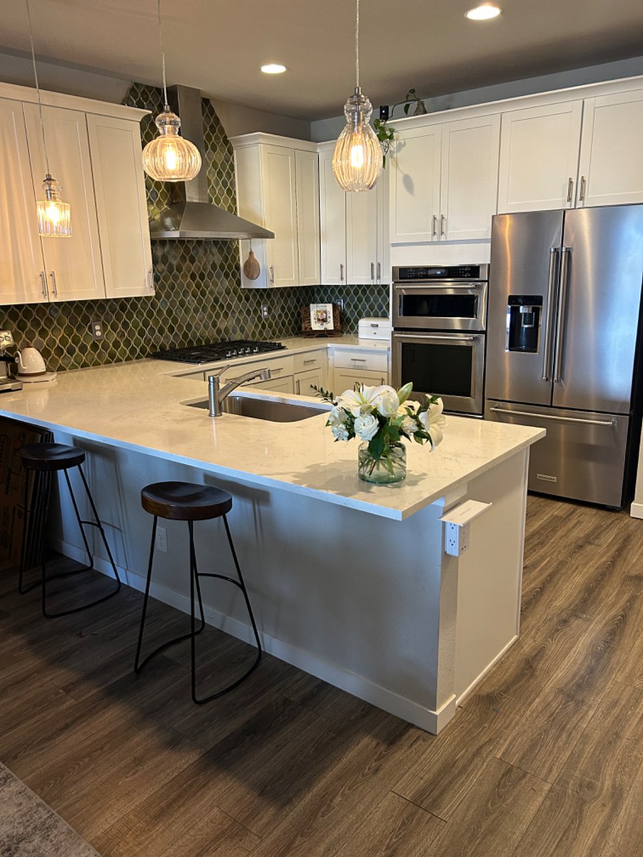 Spacious modern kitchen with high end appliances and large kitchen island or nearby dining table.
