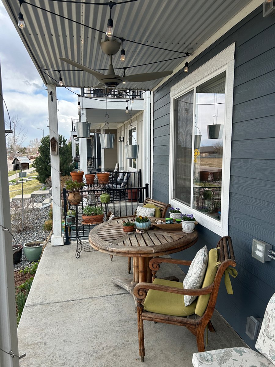 Sunny east facing porch with ceiling fan and evening party lights.