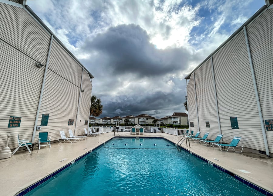 large swimming pool and patio for grilling overlooking lake