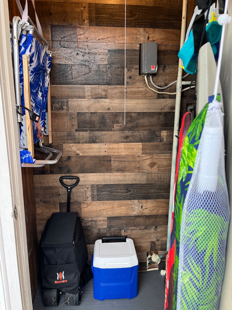 Our own Beach Closet outside front door with chairs, umbrella, beach wagon and coolers for you to use!