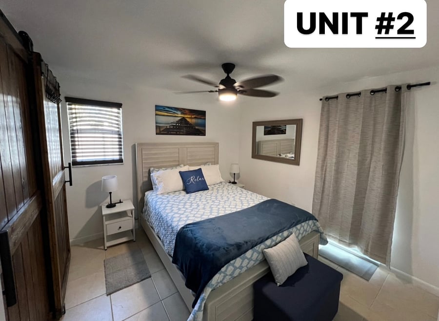 BEDROOM IN UNIT #2.
QUEEN SIZE BED.
WINDOW TINT AND DARKENING CURTAIN ADDED TO GLASS DOOR FOR OUR GUESTS WHO WORK AT NIGHT AND SLEEP DURING THE DAY.