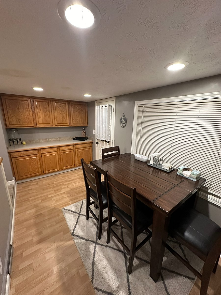 Oak kitchen cabinets. 4-person dark-oak kitchen table in dining room area. 