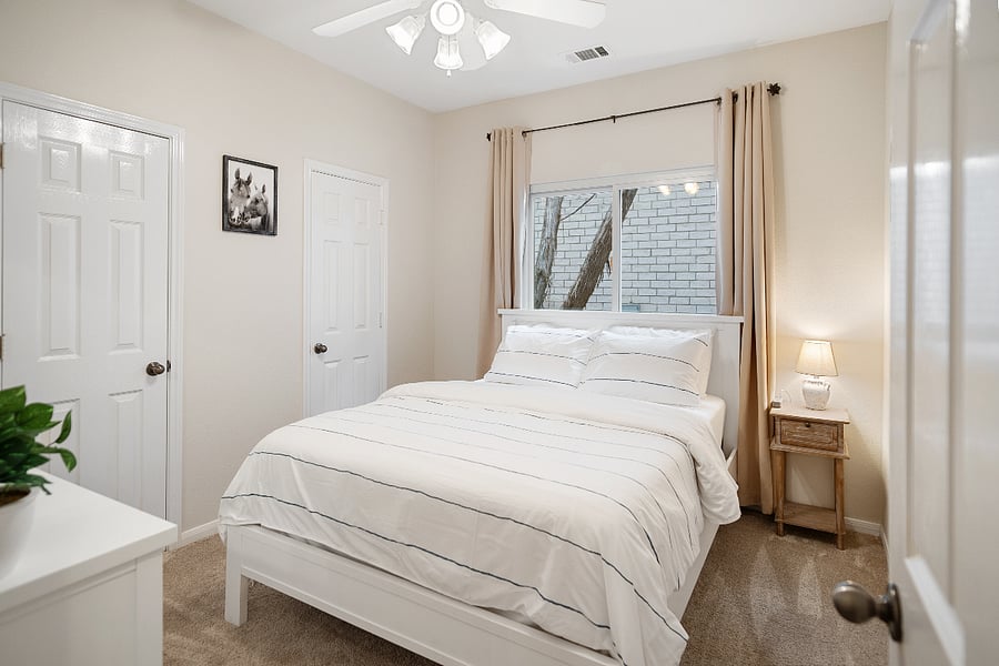 Secondary bedroom with queen bed, dresser and plenty of closet space