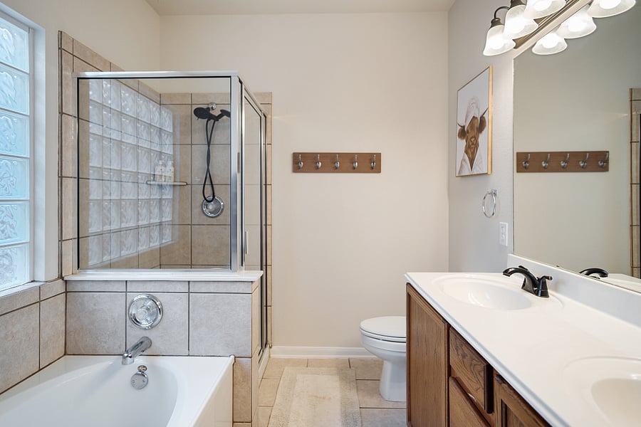 Master bath with dual sinks and separate tub and shower