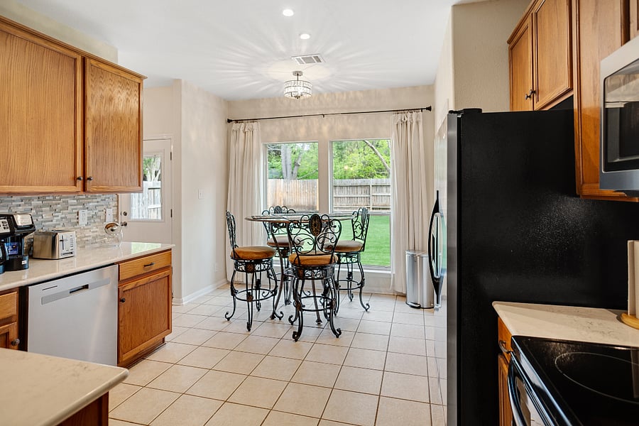 Fully equipped eat-in kitchen offers ice-maker in fridge, dishwasher and oven range.